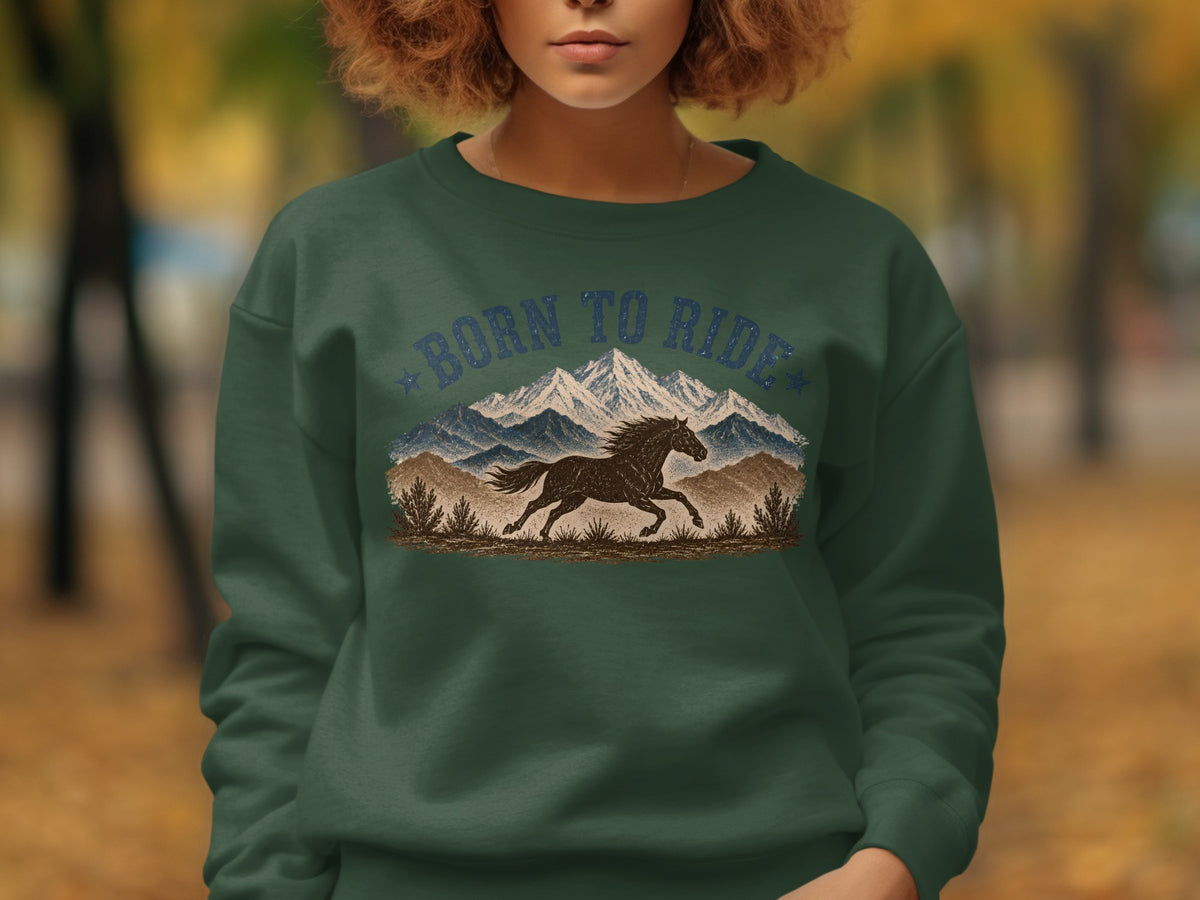 Green sweatshirt with "Born to Ride" text, mountains, and a running horse graphic.