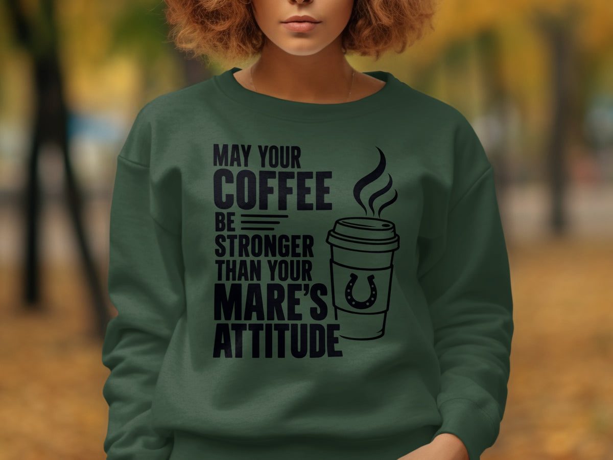 Green sweatshirt with black text and coffee cup graphic reading "May your coffee be stronger than your mare's attitude."