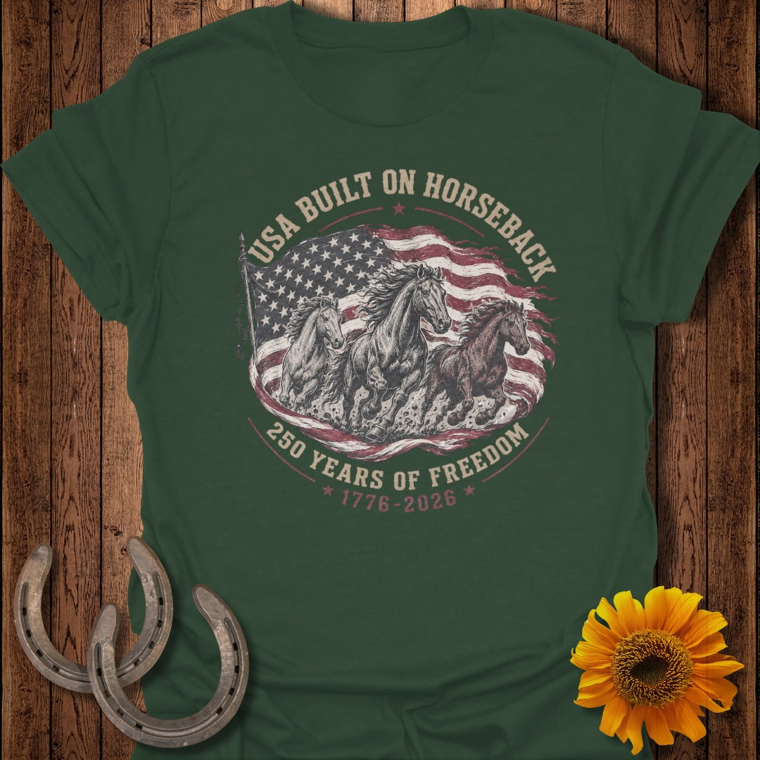 Green t-shirt with horses running in front of a distressed US flag, 250 years of freedom.
