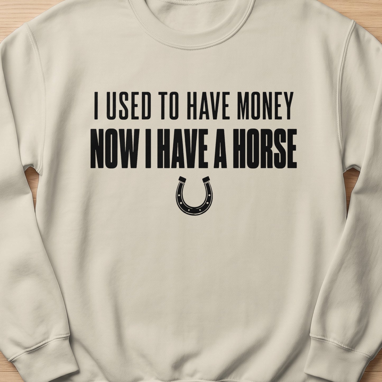 Light tan sweatshirt with black text "I used to have money now I have a horse" and horseshoe graphic.