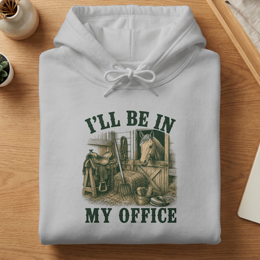 White hoodie with "I'll be in my office" text and horse in stable graphic.