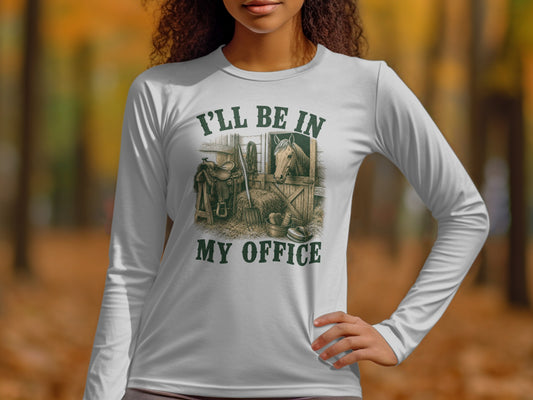 White long-sleeve shirt with graphic of a horse in a stable and text "I'll be in my office".