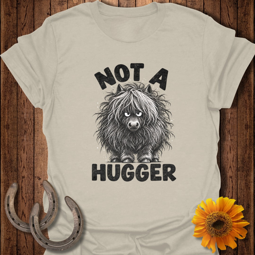 Beige t-shirt featuring a grumpy Highland cow graphic with the text Not A Hugger.