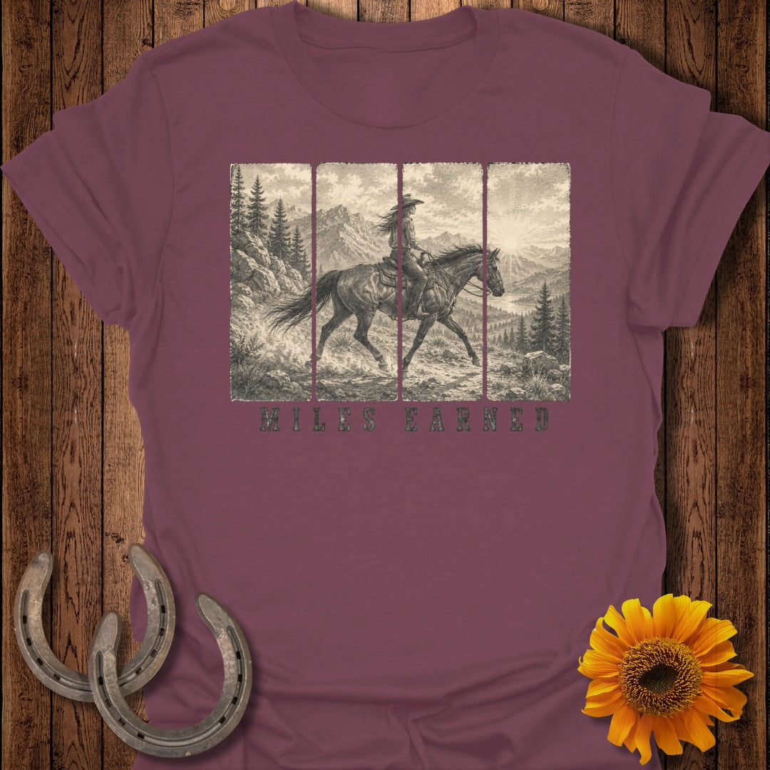 Maroon t-shirt with vintage western rider graphic and "Miles Earned" text.