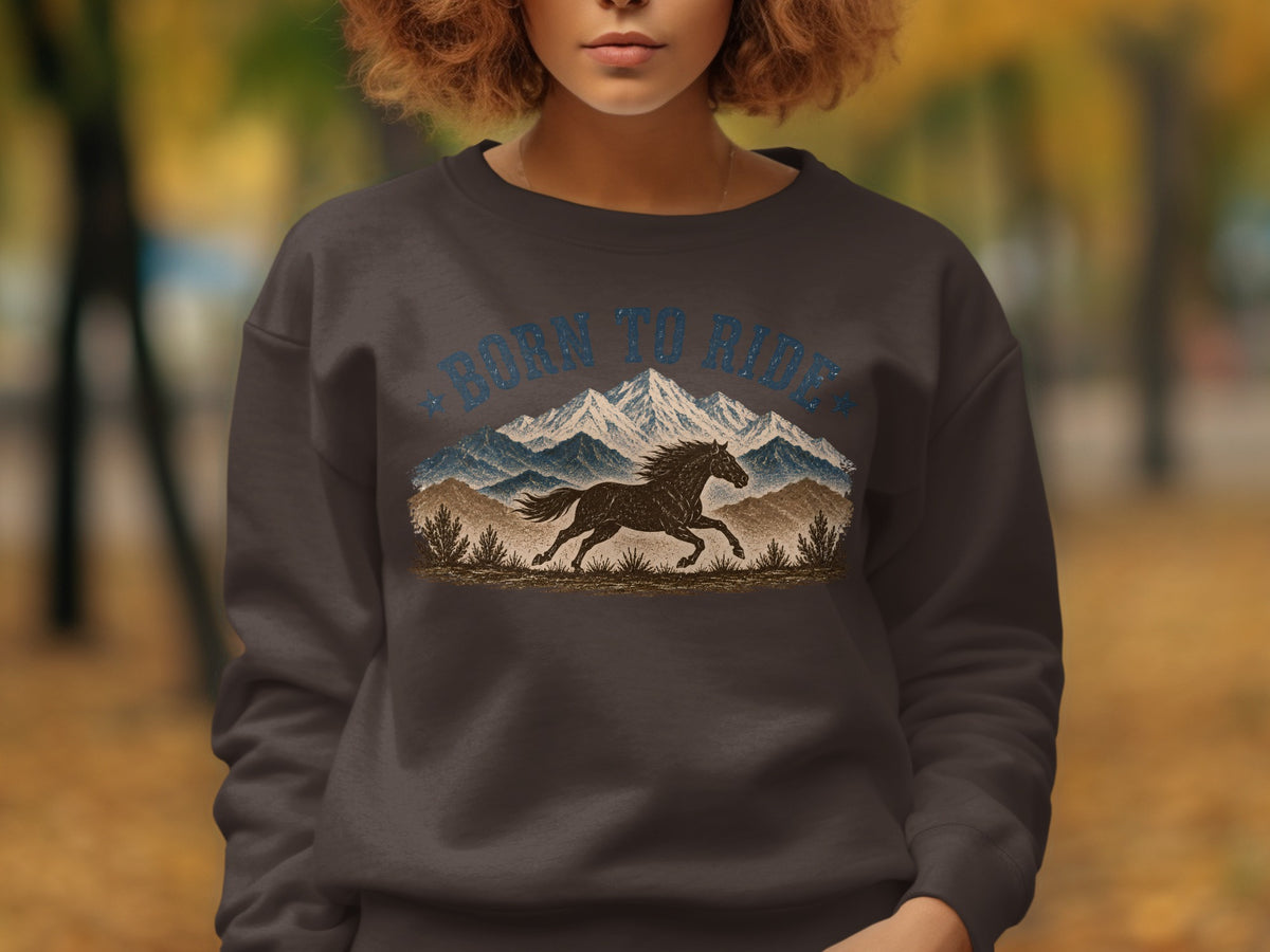 Dark sweatshirt with "BORN TO RIDE" text, running horse, and mountains graphic.