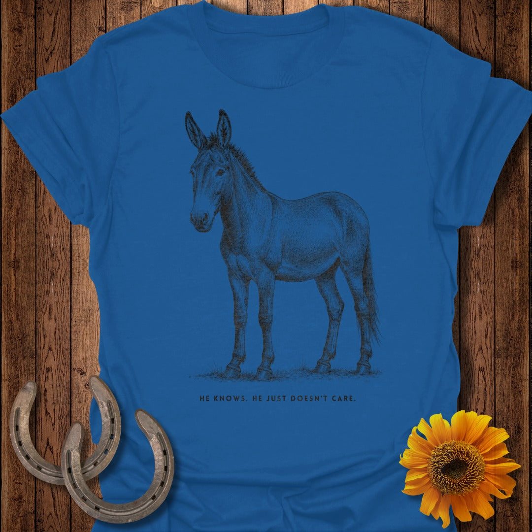 Blue t-shirt with a sketch of a mule and text "HE KNOWS. HE JUST DOESN'T CARE."