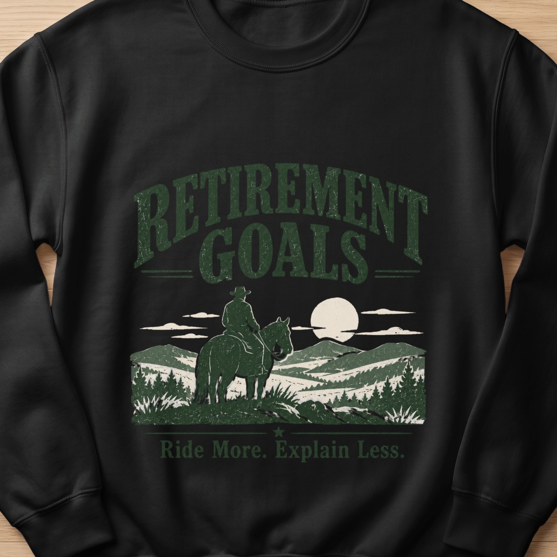 Black sweatshirt with "Retirement Goals" and "Ride More. Explain Less." text and horse graphic.