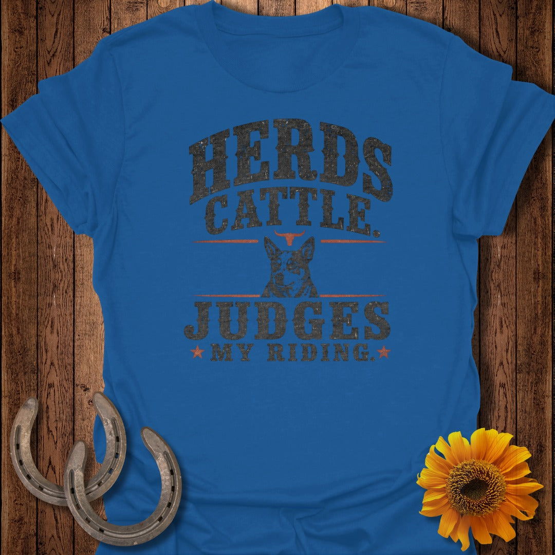 Blue t-shirt with "Herds Cattle Judges My Riding" text and a dog illustration.