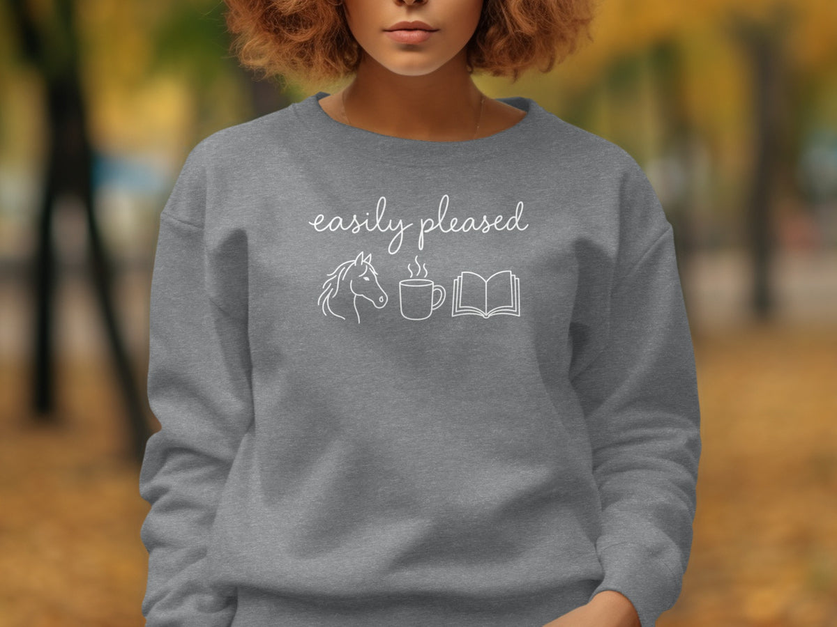 Grey sweatshirt with "easily pleased" text, horse, coffee cup, and book graphics.