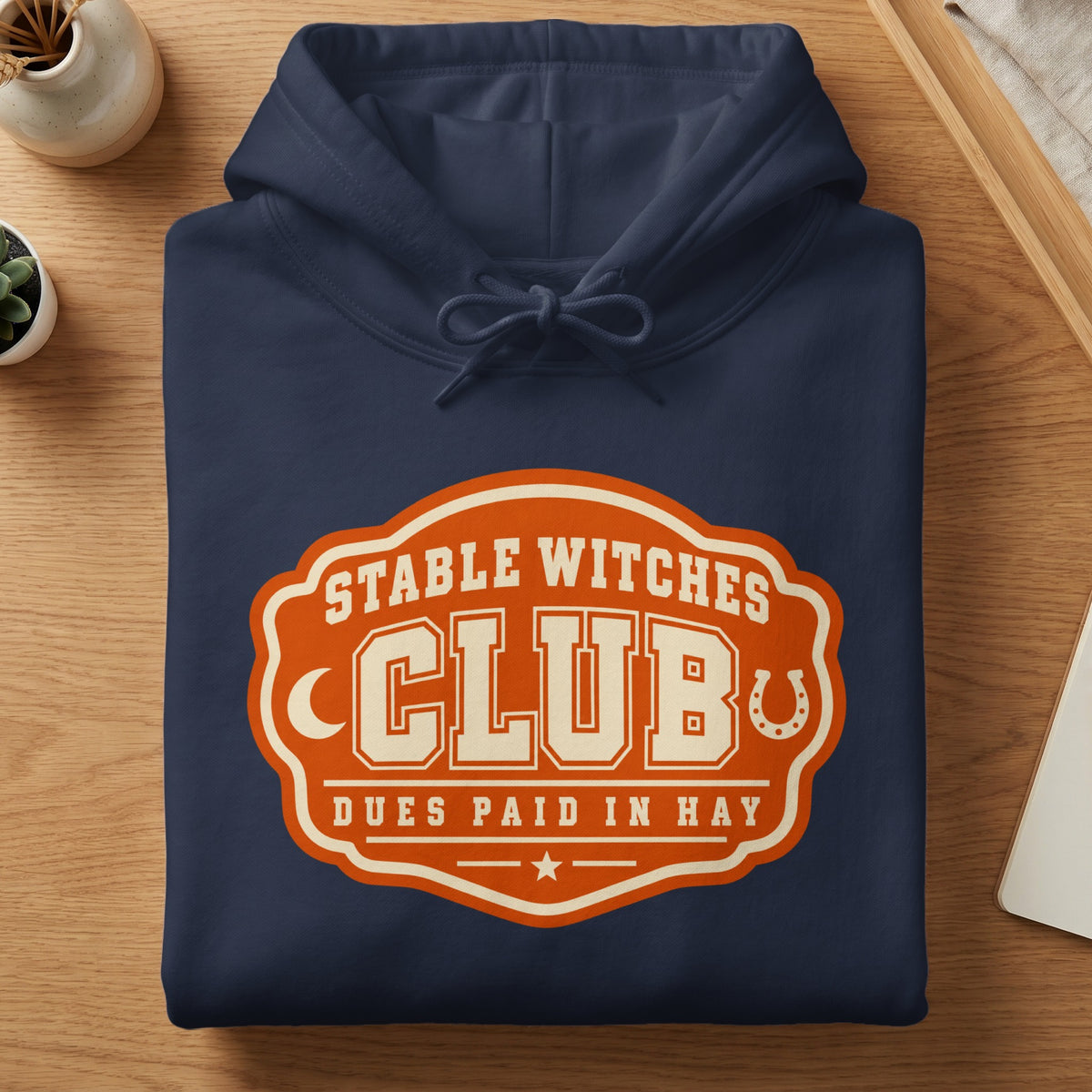 Navy blue hoodie with "Stable Witches Club Dues Paid in Hay" graphic.