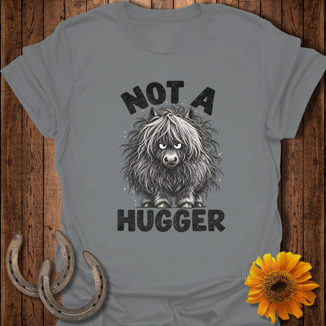 A gray t-shirt featuring a grumpy, shaggy highland cow illustration with the text NOT A HUGGER.