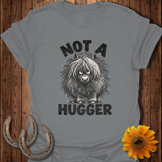 A gray t-shirt featuring a grumpy, shaggy highland cow illustration with the text NOT A HUGGER.
