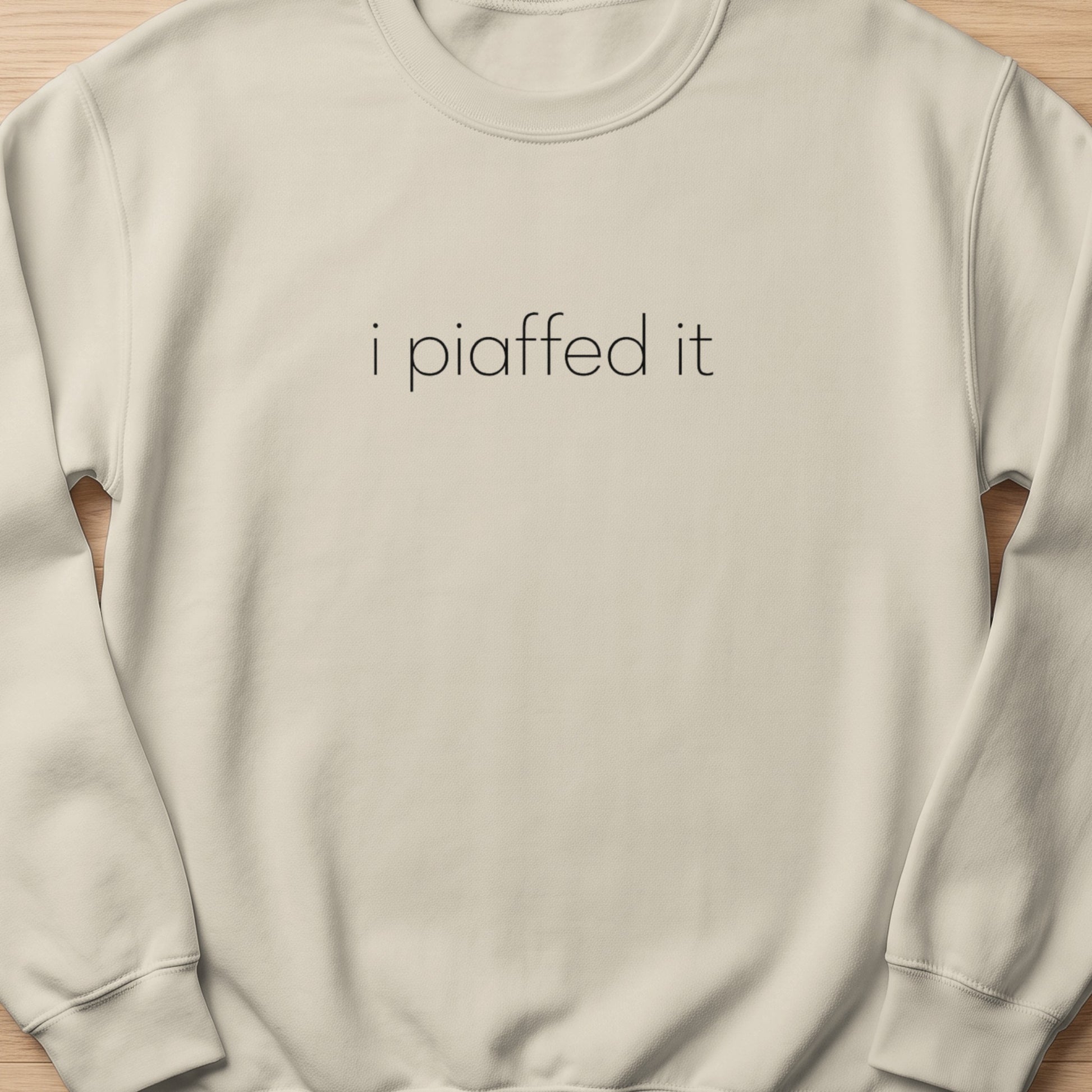 Cream sweatshirt with "i piaffed it" text in black.