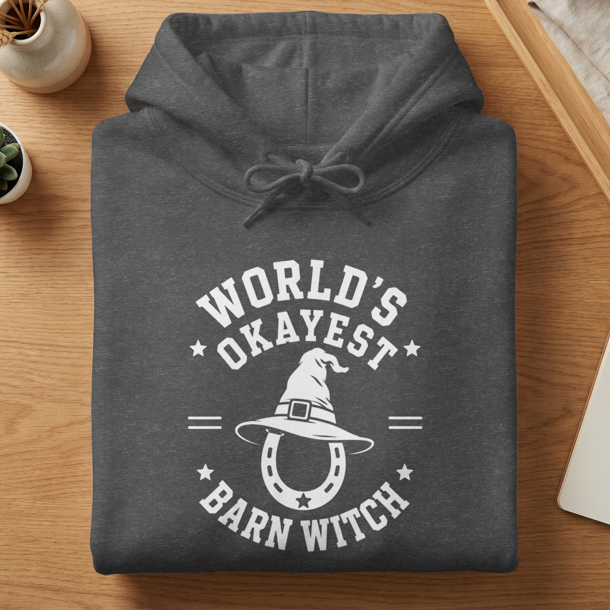 Dark grey hoodie with white text and graphic: "World's Okayest Barn Witch".