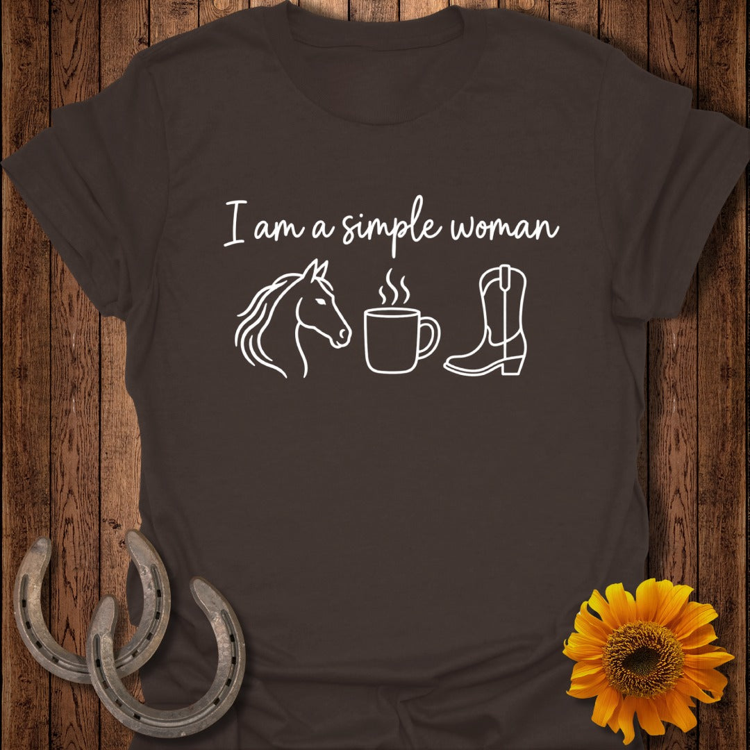 A dark brown t-shirt featuring white text that reads I am a simple woman, accompanied by icons of a horse, a steaming coffee mug, and a cowboy boot.