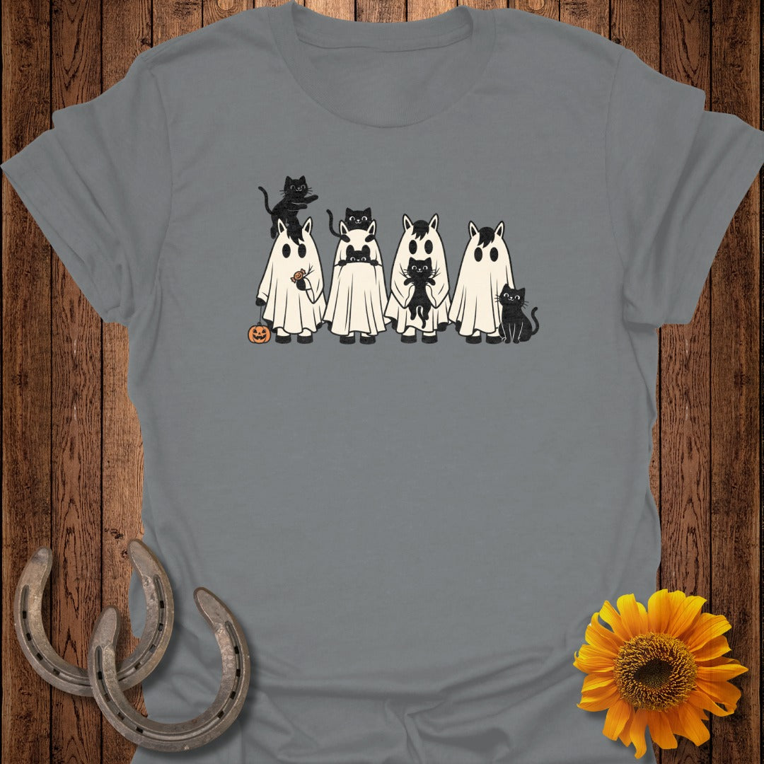 Horses in ghost costumes with black cats and a pumpkin.