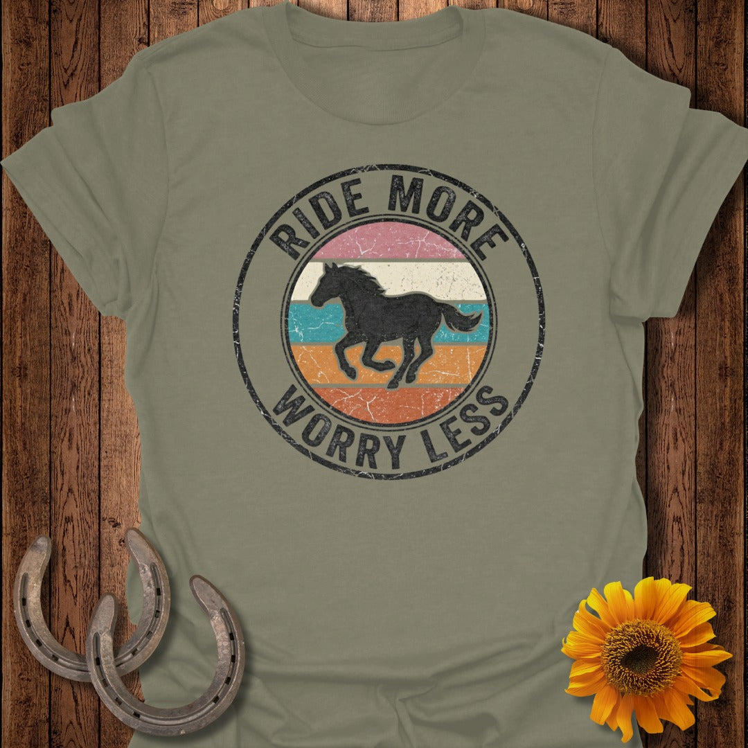 Olive green t-shirt with circular graphic of a galloping horse, "Ride More Worry Less" text.