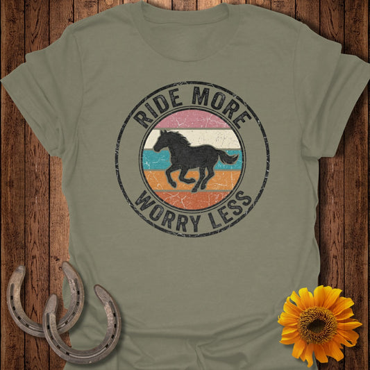 Olive green t-shirt with circular graphic of a galloping horse, "Ride More Worry Less" text.
