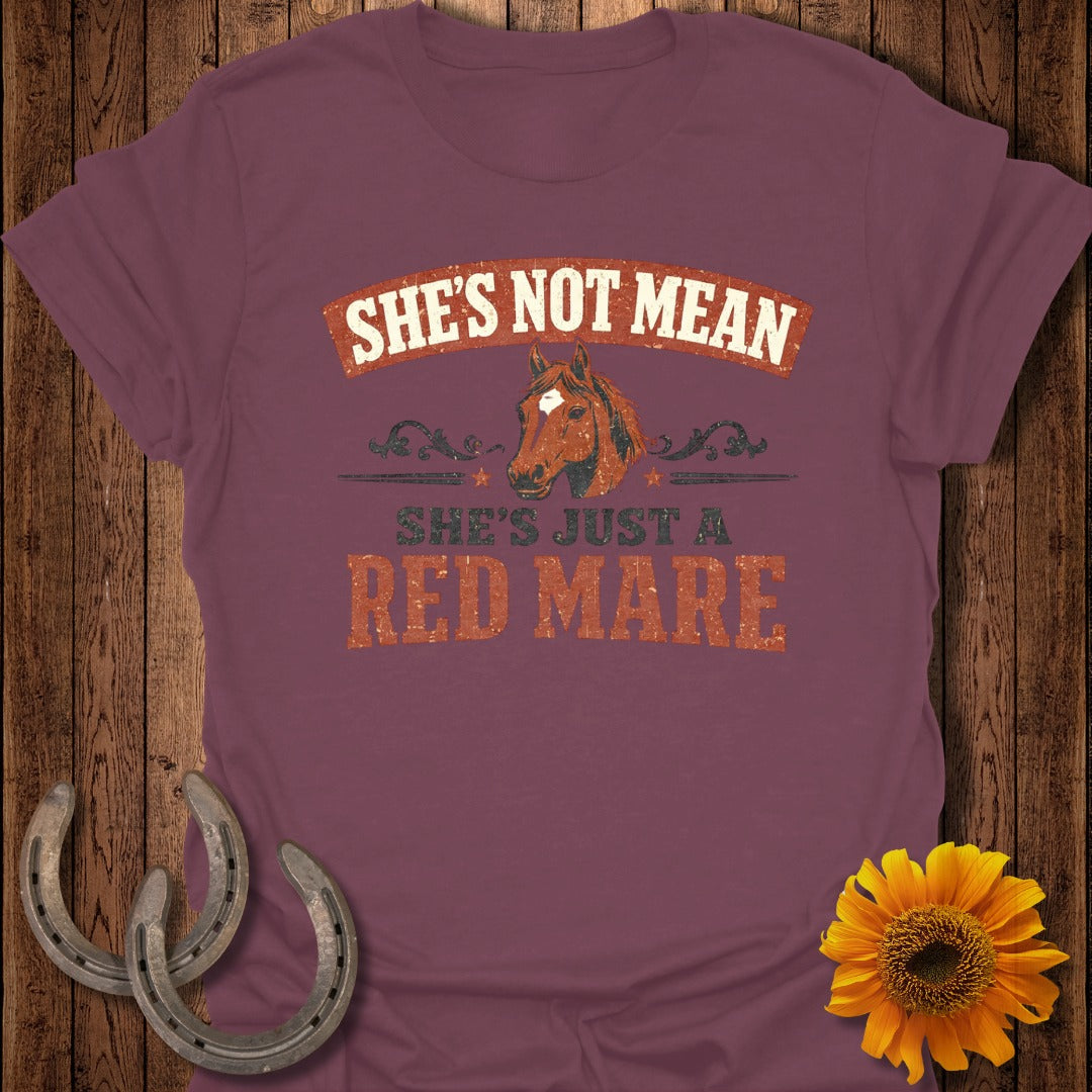 Burgundy t-shirt with distressed text "SHE'S NOT MEAN SHE'S JUST A RED MARE" and horse graphic.