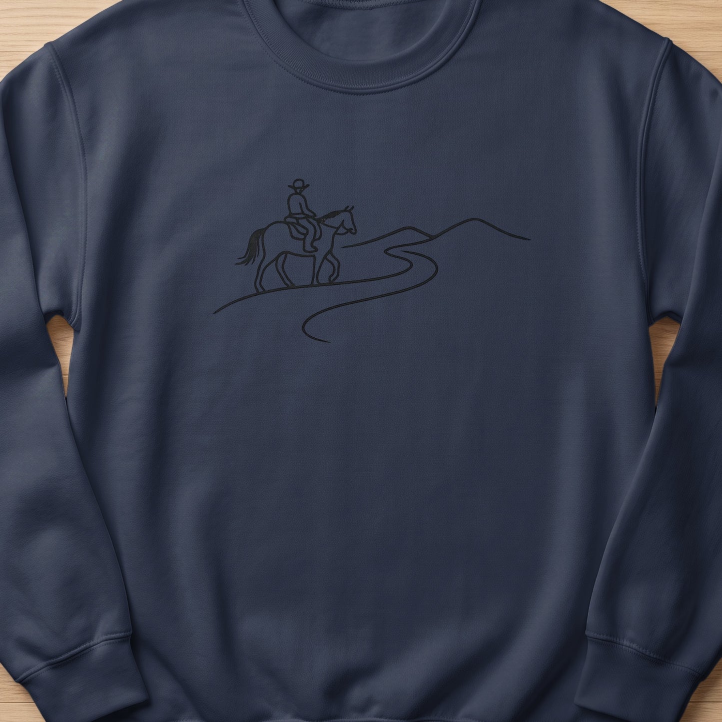 Line drawing of a person riding a horse on a winding path through hills.