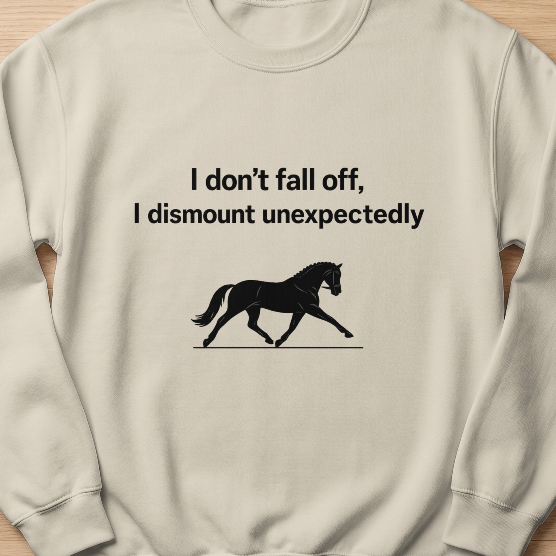 Light cream sweatshirt with black text and horse graphic: "I don't fall off, I dismount unexpectedly."