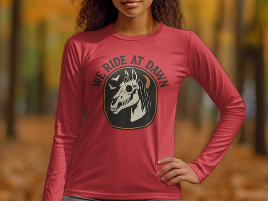 Red long-sleeve shirt with "WE RIDE AT DAWN" and horse skull graphic.