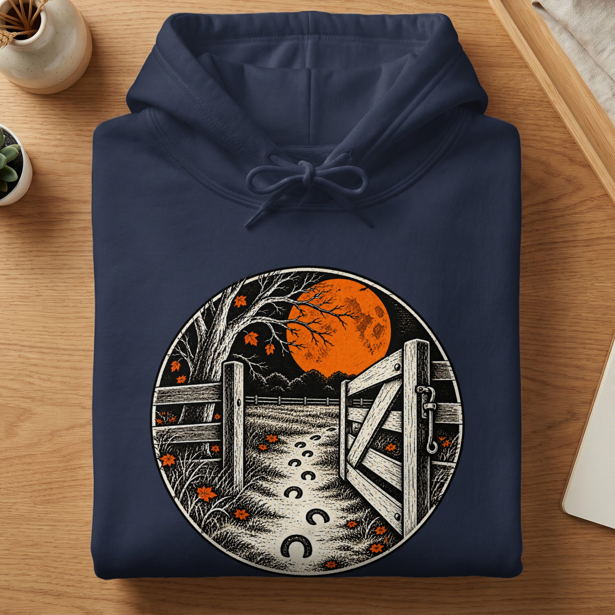 Navy hoodie with a circular print of a moonlit farm scene and horseshoe path.