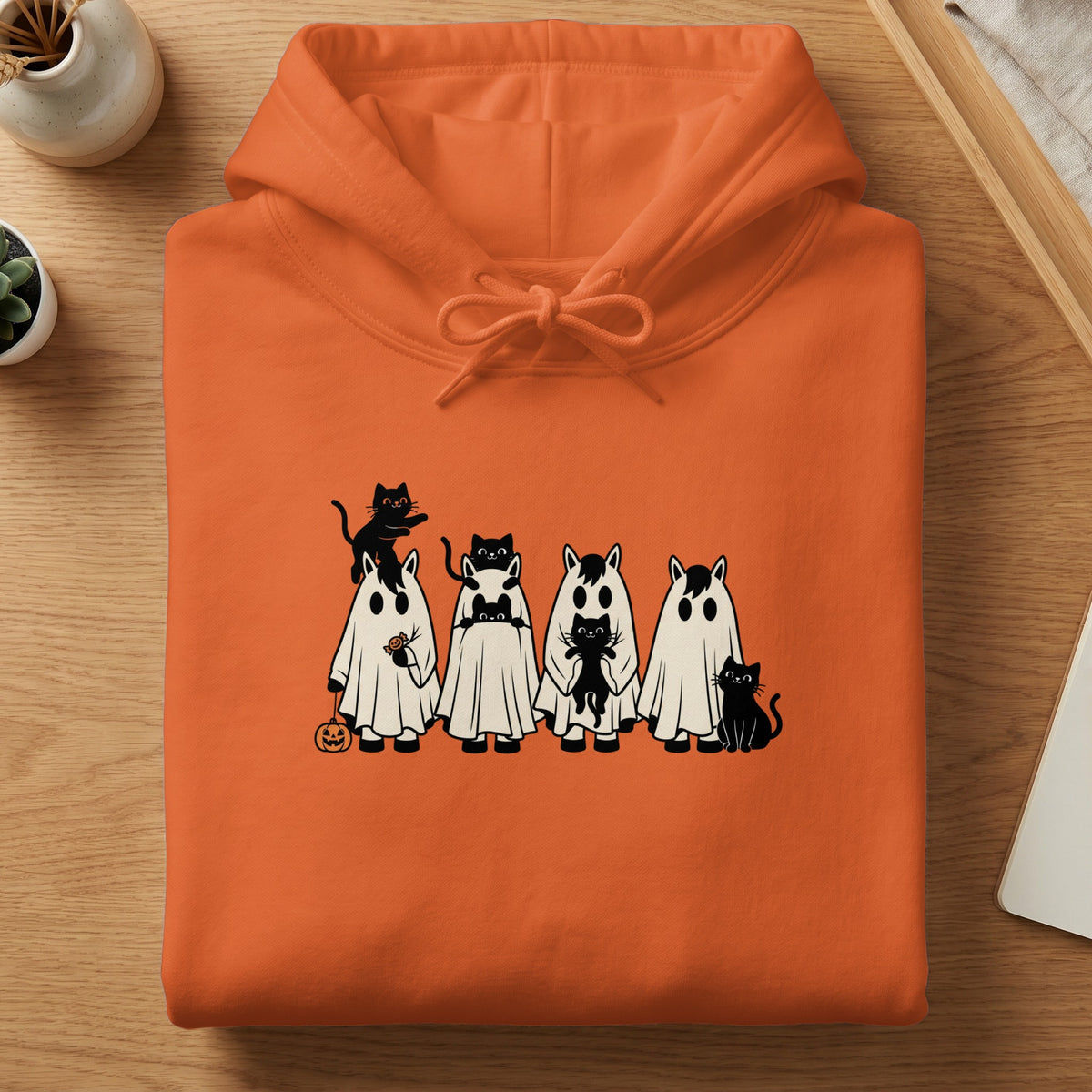 Orange hoodie with cartoon horses in ghost costumes and black cats.