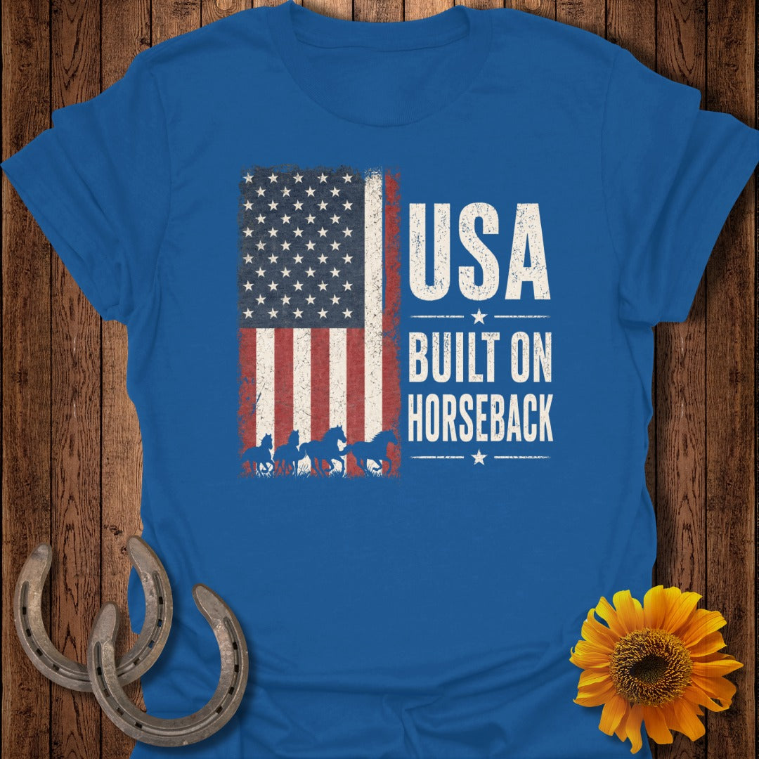 Blue t-shirt with distressed American flag and horses, text reads "USA BUILT ON HORSEBACK".