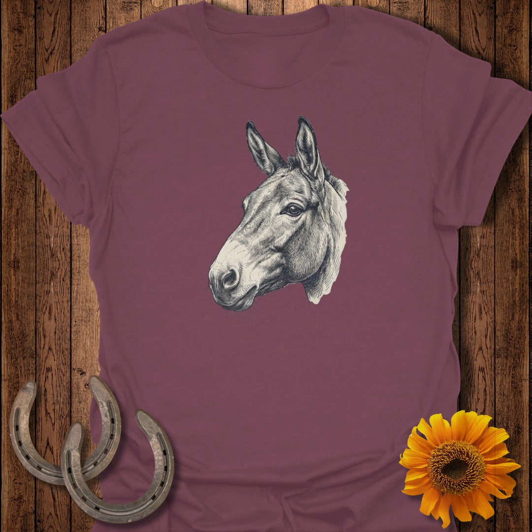 Line drawing of a mule's head on a maroon t-shirt with horseshoes.