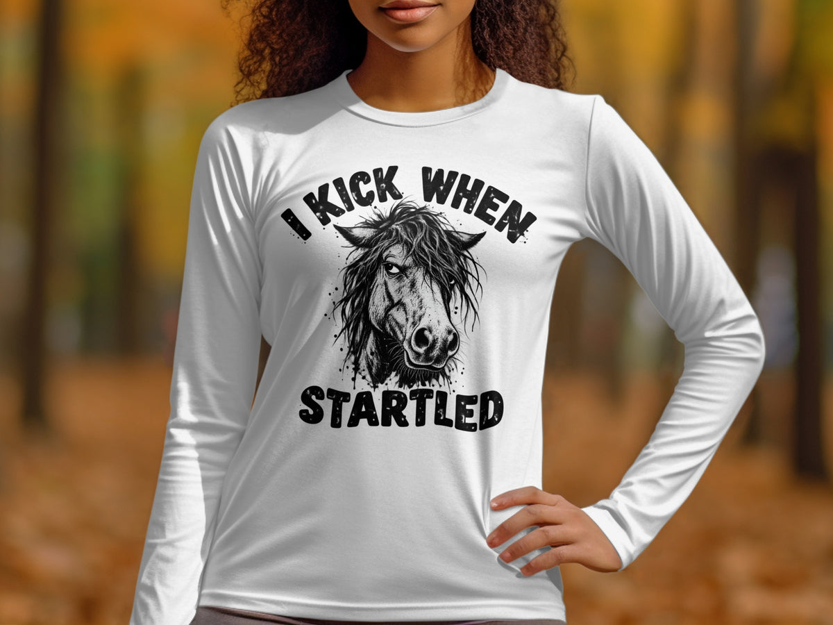 White long-sleeve shirt with a black graphic of a horse's head and text that reads "I KICK WHEN STARTLED".