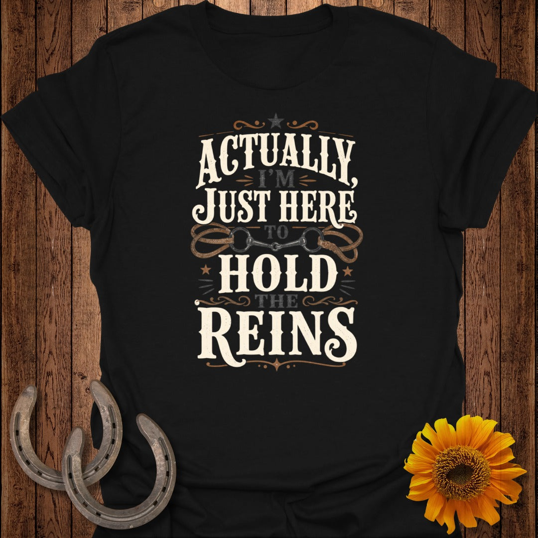 Black t-shirt with "Actually, I'm Just Here To Hold The Reins" text.