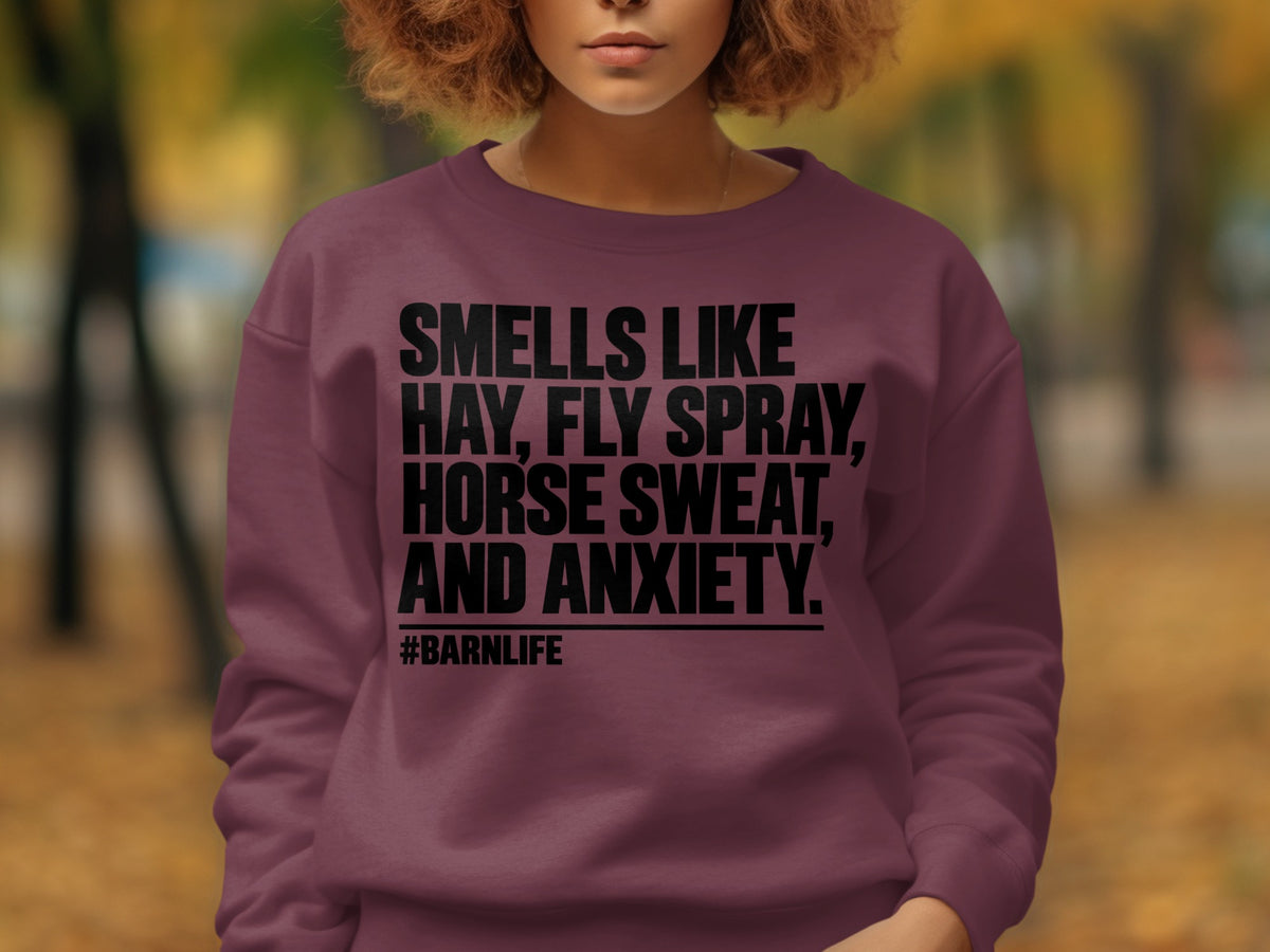 Burgundy sweatshirt with text "SMELLS LIKE HAY, FLY SPRAY, HORSE SWEAT, AND ANXIETY. #BARNLIFE"