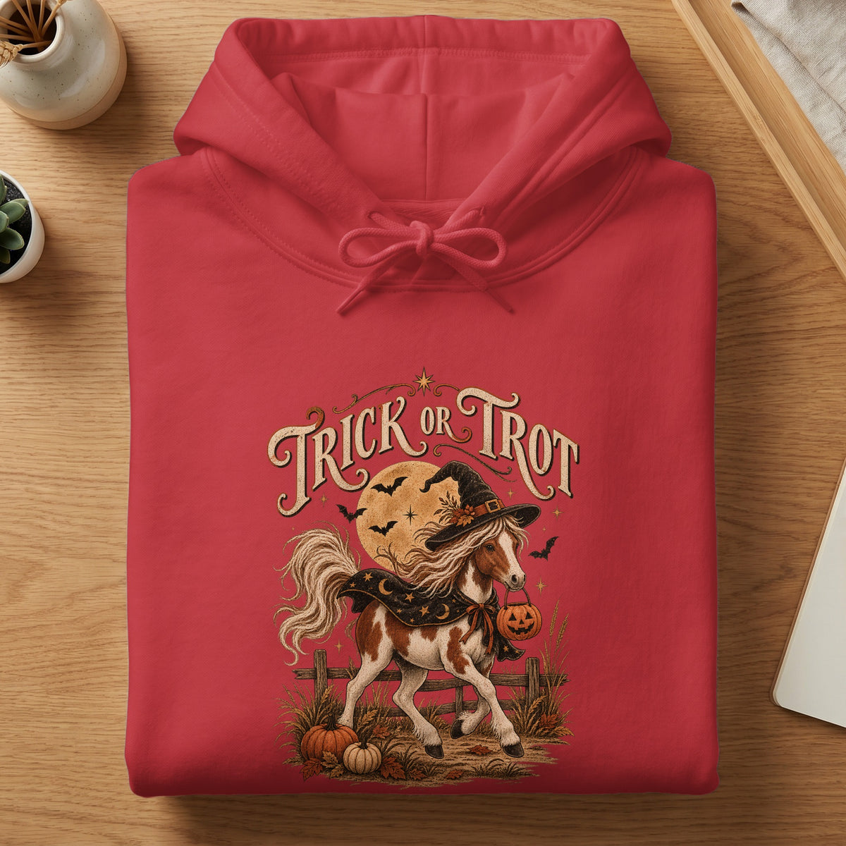 Horse wearing witch hat and holding pumpkin basket with text "Trick or Trot".