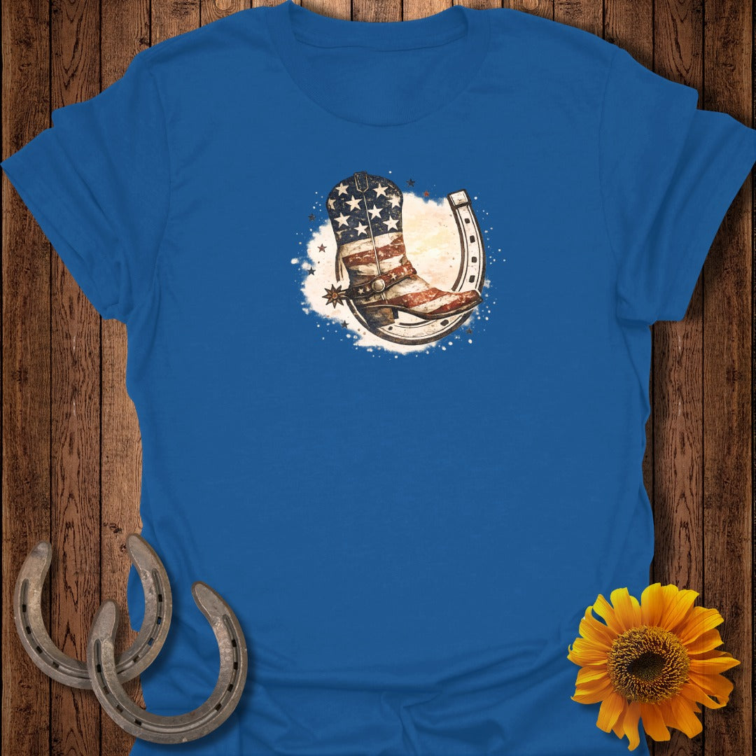 Blue t-shirt with cowboy boot and horseshoe with American flag design.