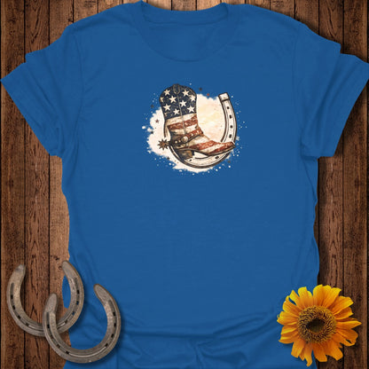 Blue t-shirt with cowboy boot and horseshoe with American flag design.