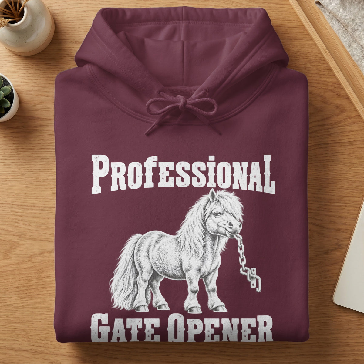 A maroon hoodie printed with a white graphic of a pony holding a chain and the text "Professional Gate Opener".