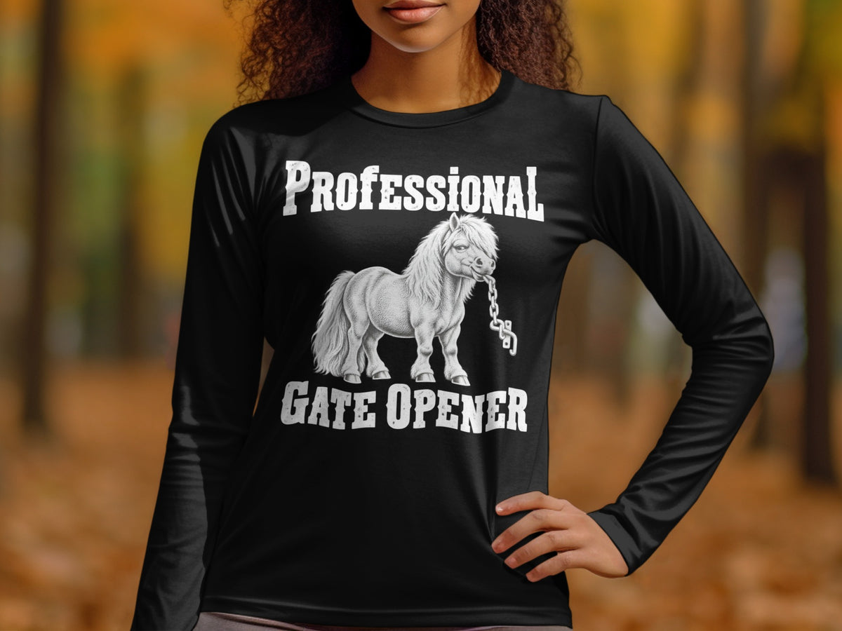A woman wearing a black long-sleeve t-shirt with a graphic of a horse holding a chain and the text PROFESSIONAL GATE OPENER.