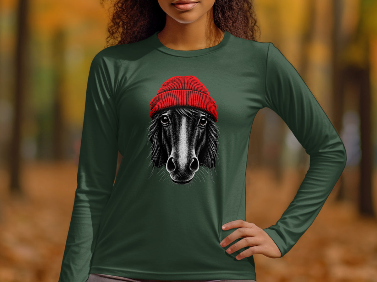 A woman wearing a dark green long-sleeve t-shirt with a graphic of a black horse wearing a red beanie.