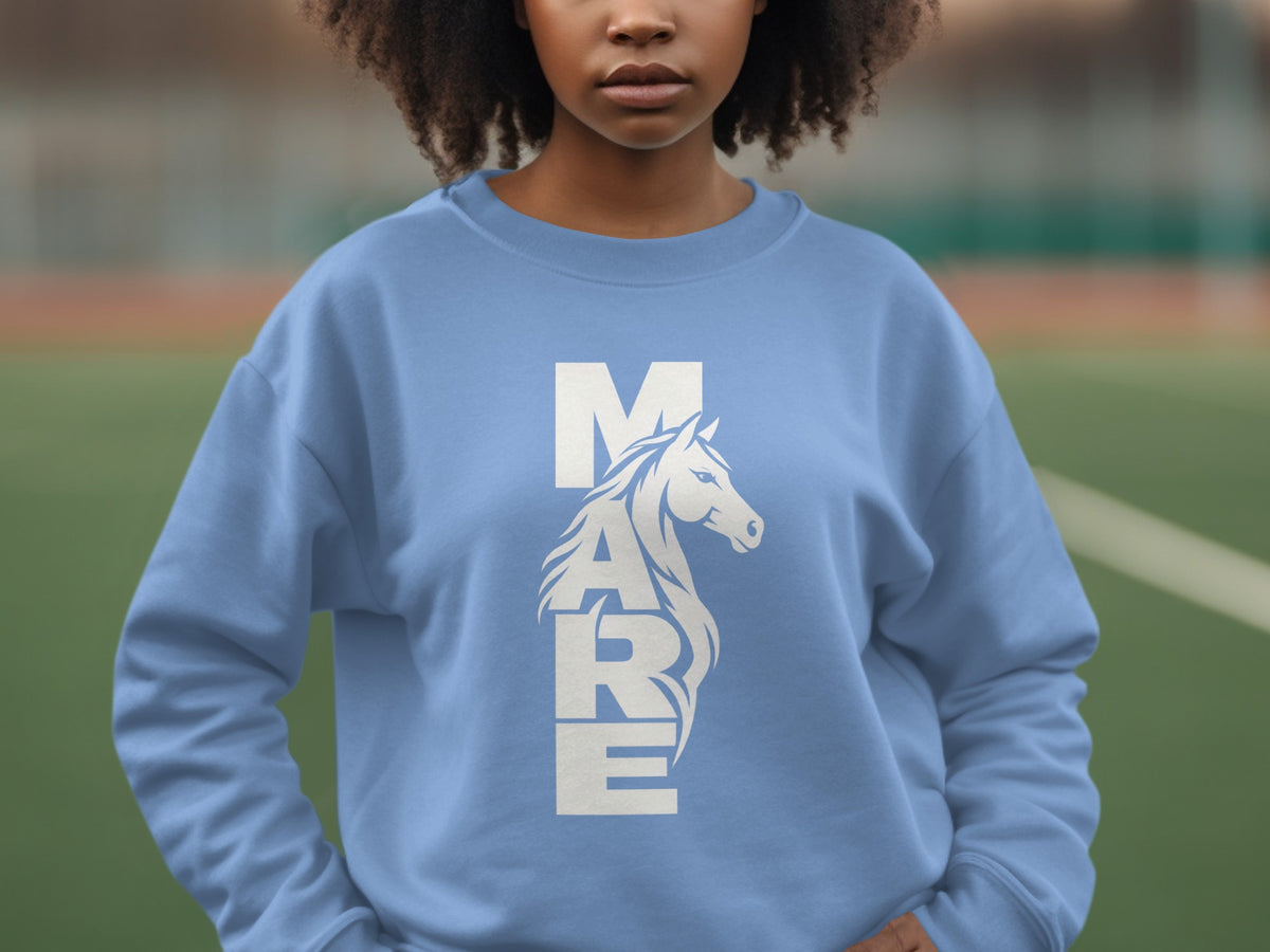 A person wearing a light blue crewneck sweatshirt with the white text MARE incorporating a horse illustration.