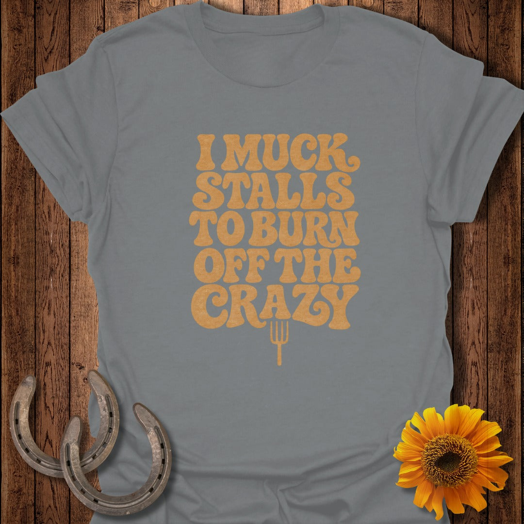 A grey t-shirt featuring yellow text that reads "I Muck Stalls to Burn off the Crazy."