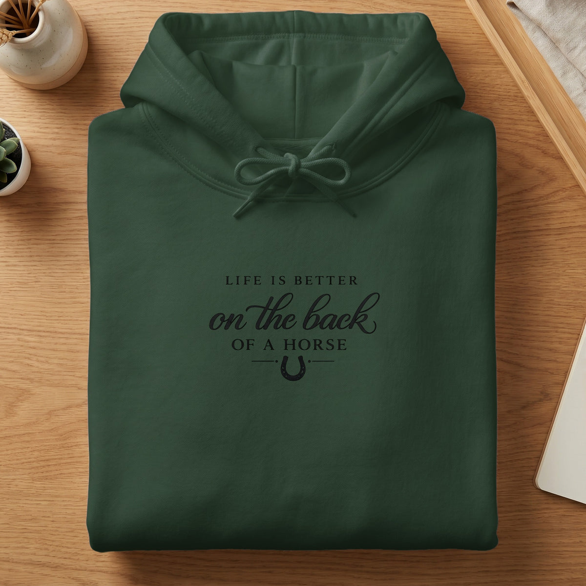 Dark green hoodie with "Life is better on the back of a horse" text and horseshoe.