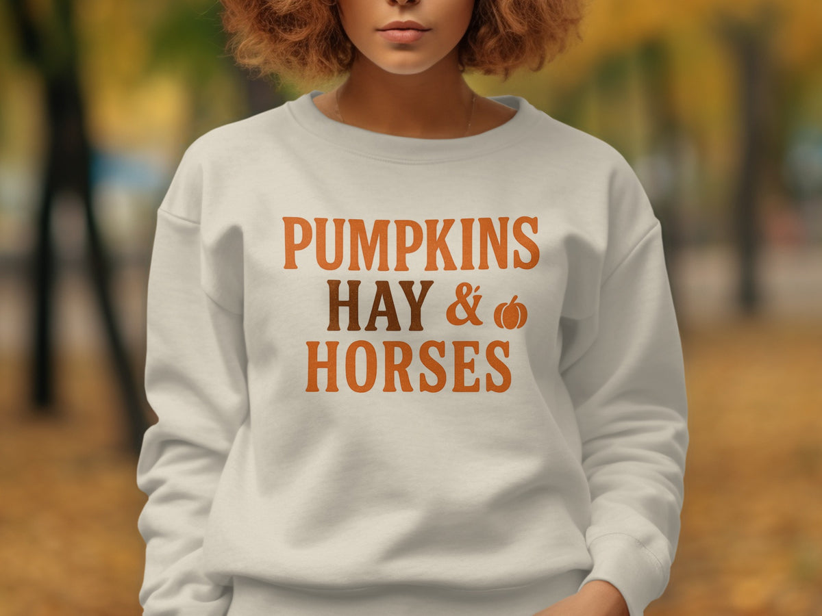 White crewneck sweatshirt with text "PUMPKINS HAY & HORSES".