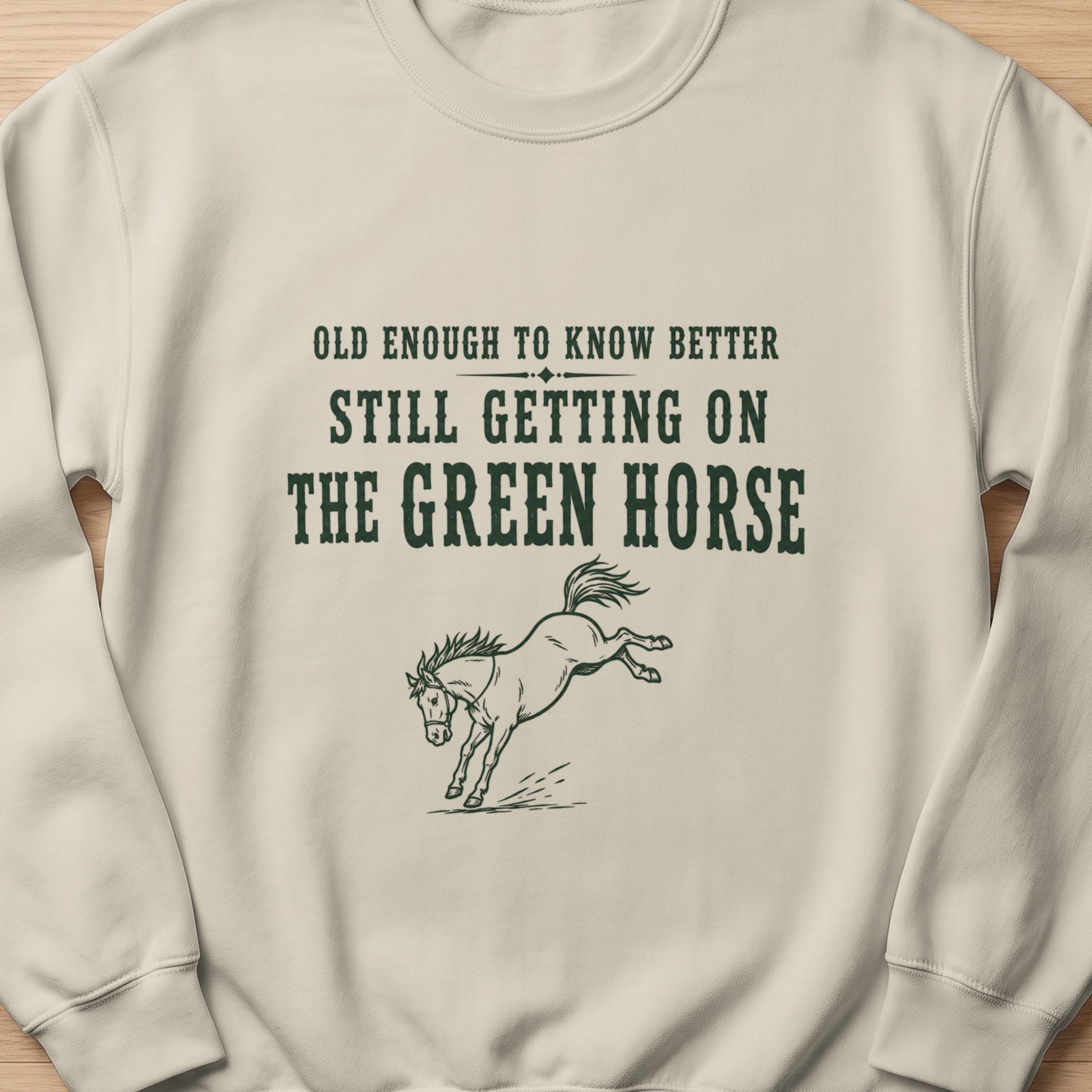 Lightweight crewneck sweatshirt with "Old enough to know better still getting on the green horse" text and horse graphic.