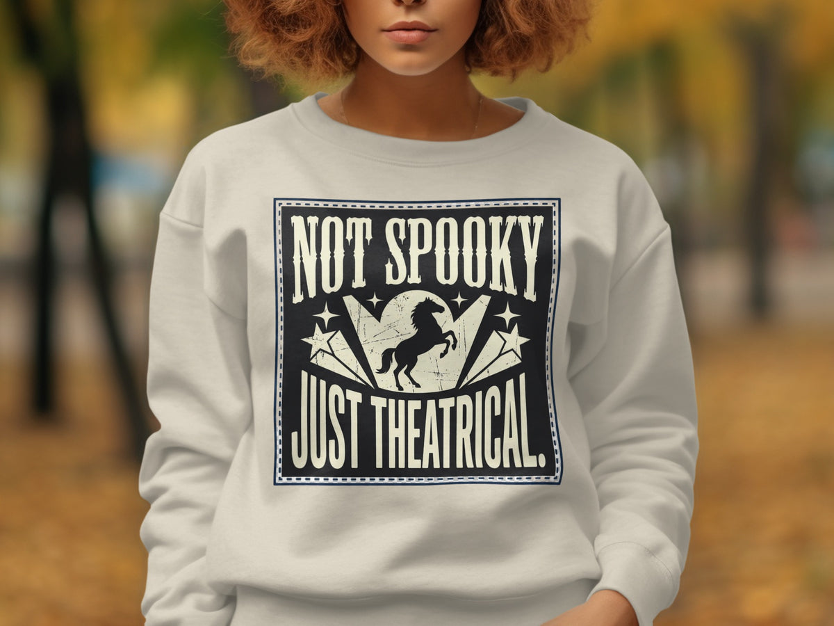 Cream sweatshirt with "NOT SPOOKY JUST THEATRICAL" text and a horse graphic.
