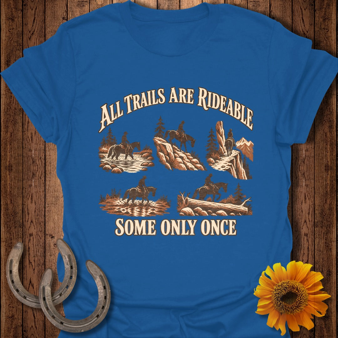 Blue t-shirt with a graphic of five horseback riding scenes and text "All Trails Are Rideable Some Only Once".