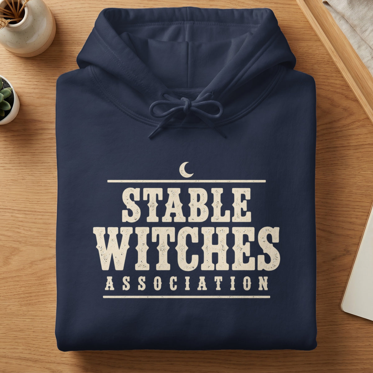 Navy hoodie with distressed "STABLE WITCHES ASSOCIATION" text and crescent moon graphic.