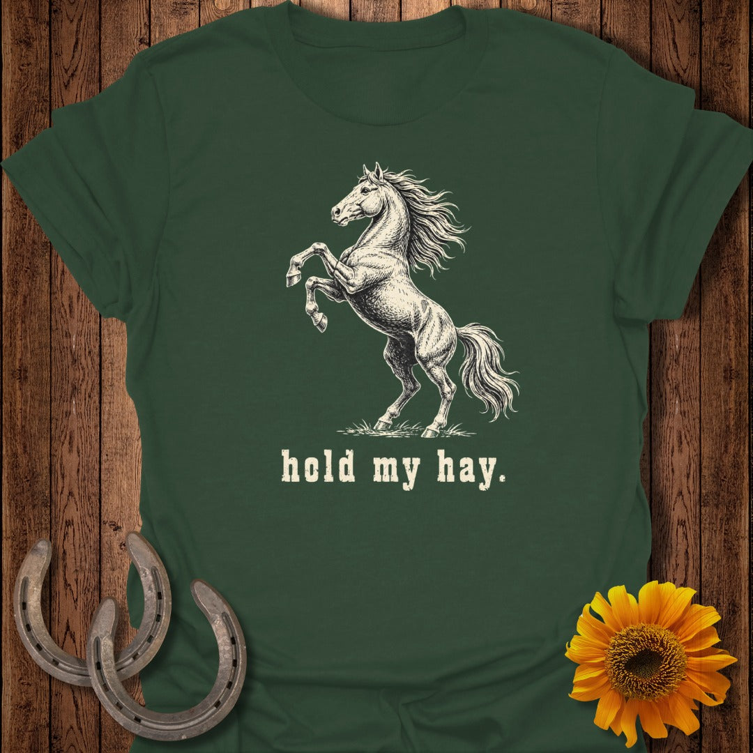 The dark green t-shirt features a drawing of a rearing horse and the text "hold my hay."