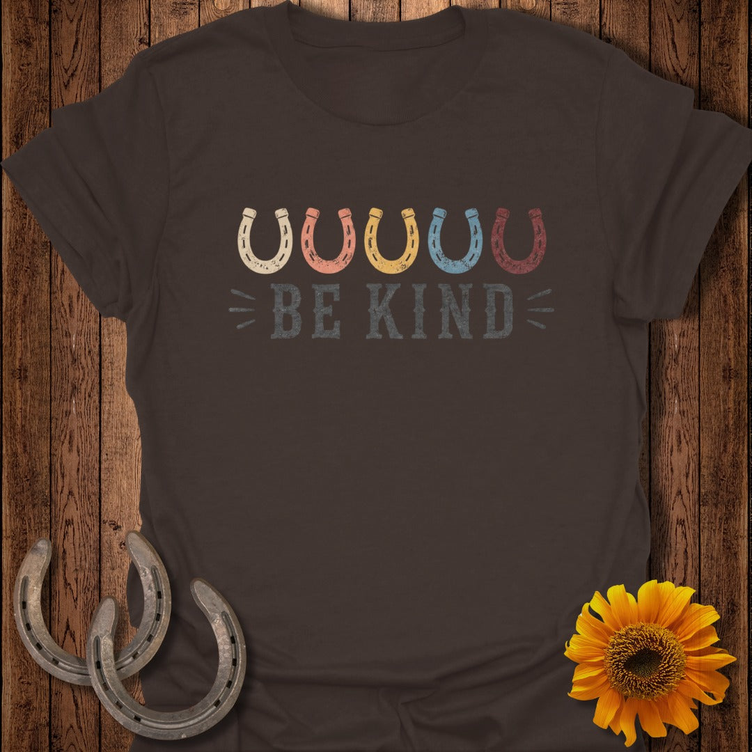 Brown t-shirt with "BE KIND" and colorful horseshoes.