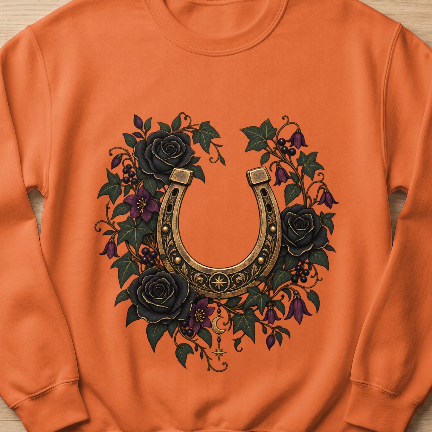 Orange sweatshirt with a vintage horseshoe surrounded by black roses and vines.